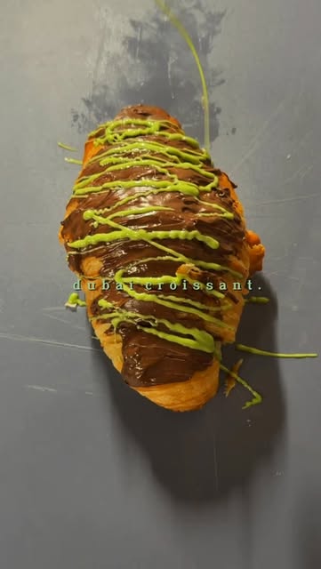 A pastry with dark chocolate and bright green topping photographed by Haifa Coffeehouse